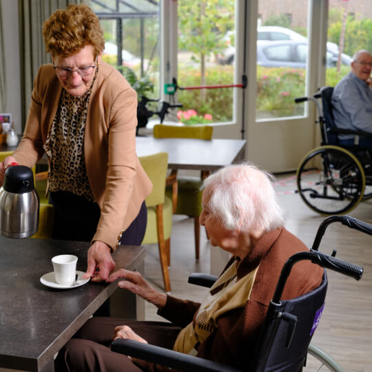 Triangel - vrijwilliger schenkt koffie